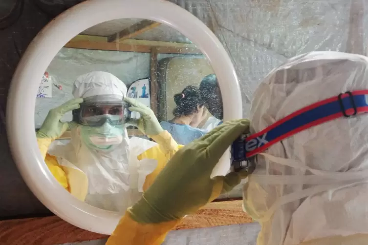 Eine Krankenschwester von Ärzte ohne Grenzen prüft ihre Sicherheitskleidung im Einsatz während der Ebola-Epidemie 2014 in Guinea