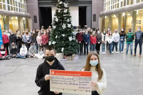  Marcel Mang aus der 10a und Lara Stephan aus der 9a präsentierenden Spendenscheck, ganz rechts steht Schulleiter Jörg Neurohr. 