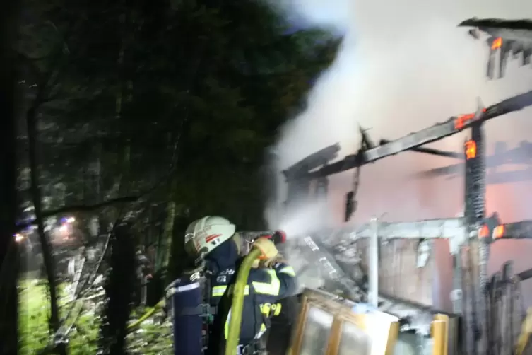 Die Feuerwehr beim Löschen des brennenden Gebäudes. 
