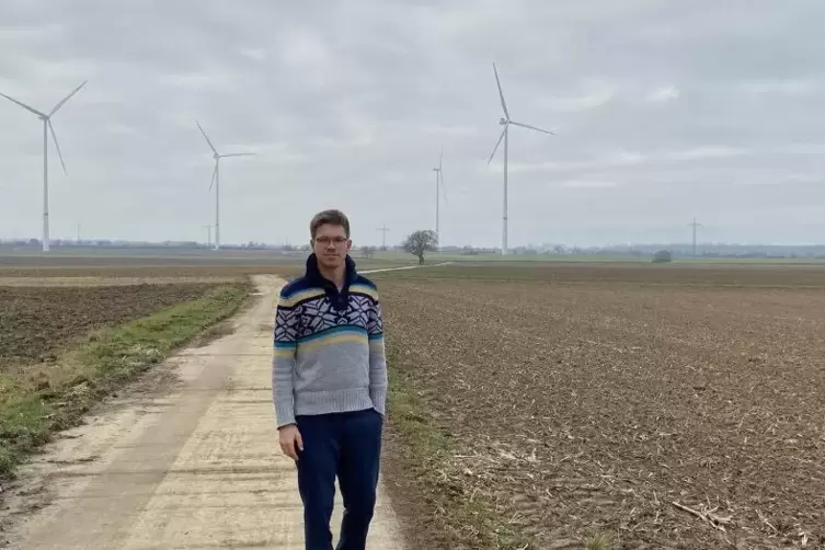 Windpark-Initiator Nicolas Schweigert : Im Hintergrund sind die Windräder bei Schwegenheim zu sehen.