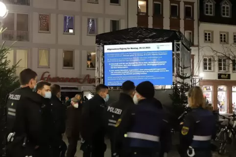 Die Allgemeinverfügung der Stadt zum Verbot sogenannter Montagsspaziergänge wird auf einer LED-Wand auf dem Rathausplatz angezei