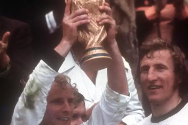 Die Kr&ouml;nung f&uuml;r Berti Vogts als Spieler: 1974 in M&uuml;nchen mit dem Weltmeisterschaftspokal. Rechts Nationalmannschaftskollege &bdquo;Kat