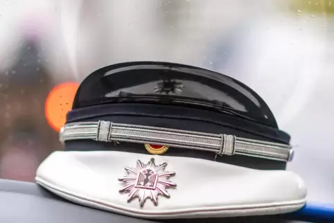  Die Mütze eines Bundespolizisten liegt auf einem Armaturenbrett.