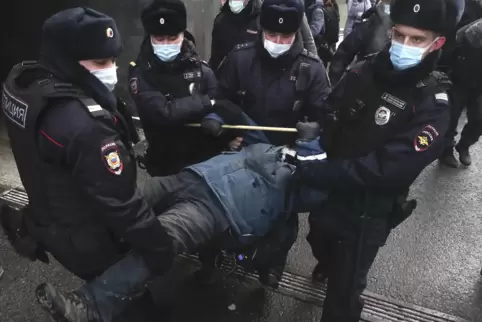 Polizisten tragen einen Demonstranten weg, der am Dienstag vor dem obersten Gerichtshof der Russischen Föderation in Moskau gege