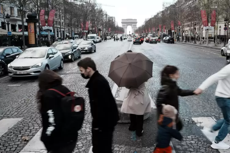 Menschen überqueren die Avenue des Champs-Elysees: Frankreich macht angesichts einer Rekordzahl von Corona-Infektionen eine voll