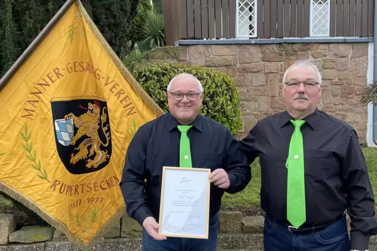 Ralf Stumpf (links) erhält vom ersten MGV-Vorsitzenden Frank Kühn die goldene Ehrennadel samt Urkunde des Chorverbandes der Pfal