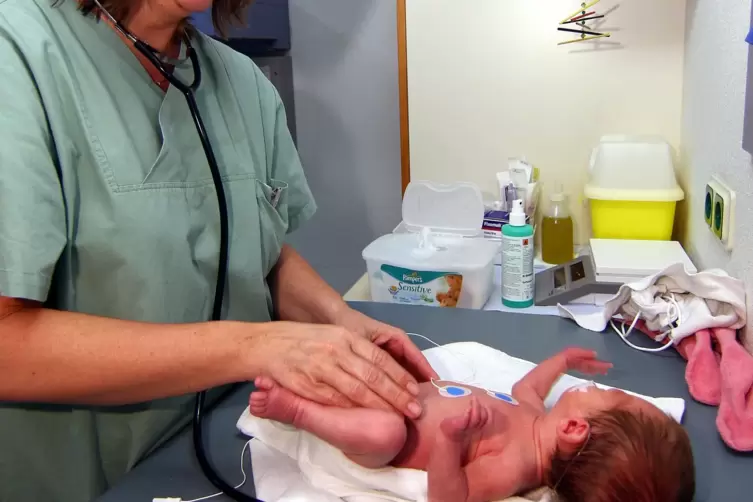 Eine Ärztin untersucht ein neugeborenes Baby an der Homburger Uni-Kinderklinik.