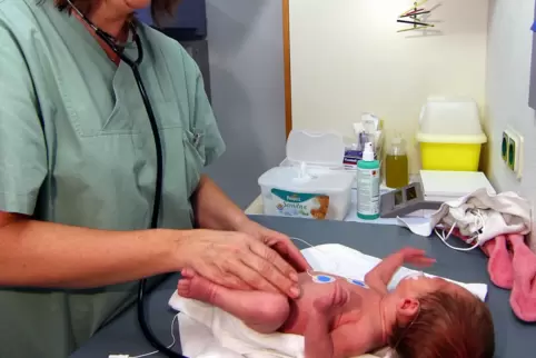 Eine Ärztin untersucht ein neugeborenes Baby an der Homburger Uni-Kinderklinik.