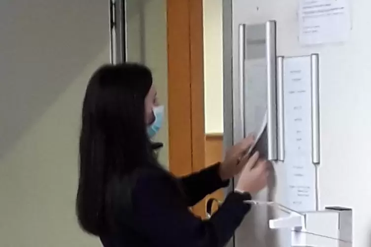 Eine Gerichtsdienerin befestigt an der Tür zu Saal 1 des Landgerichts einen Zettel, der die nächsten Verhandlungstage im Roth-Pr