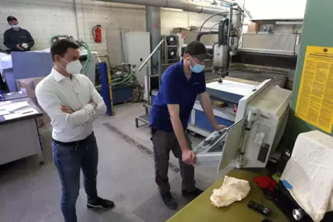 Dere heutieg Firmenchef Tim Brandenburger (links) mit seinem Mitarbeiter Steven Burkard am Pult der Wasserschneidemaschine.