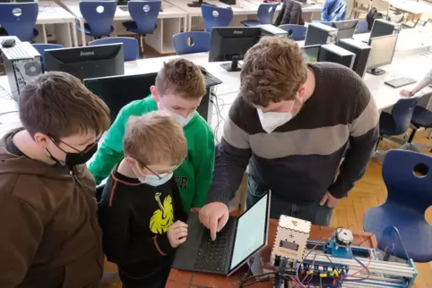 Drei Schüler der 8e und der 5b des Helmholtz-Gymnasiums bauen unter Anleitung von Lehrer Jens Römer (rechts) eine Co2-Ampel für 