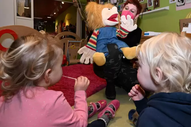 Donnerstag in der Kita Königsbach: Sophia Landeck macht den Lolli-Test mit Puppe Paula vor, die Kinder machen es nach. Donnerstag in der Kita Königsbach: Sophia Landeck macht den Lolli-Test mit Puppe Paula vor, die Kinder machen es nach.