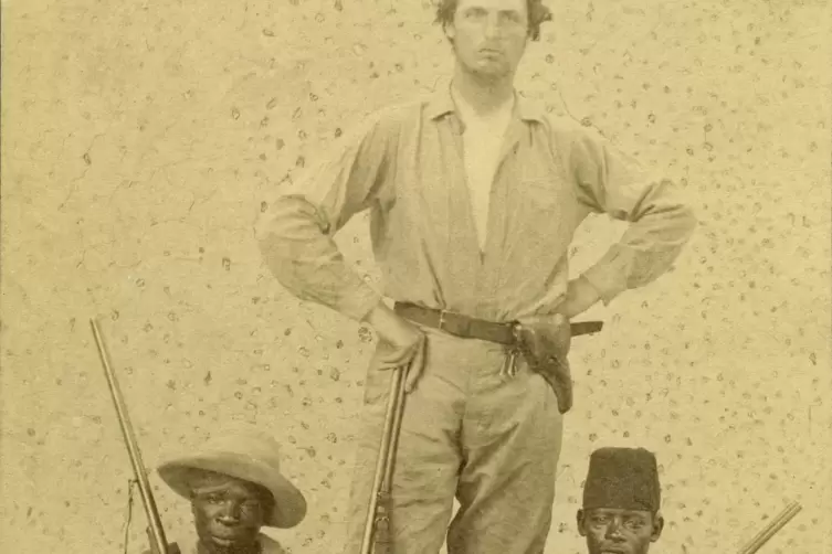 Theodor Bumiller um 1890 in Herrenpose mit zwei einheimischen Soldaten einer Milit&auml;rexpedition in Deutsch-Ostafrika.