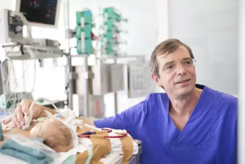 Professor Thomas Schaible bei der Behandlung eines Säuglings.