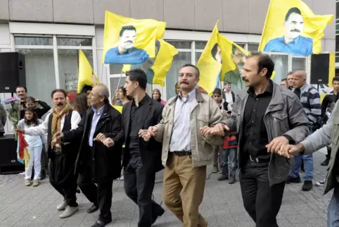 Kurden demonstrieren mit Fahnen, die das Porträt Abdullah Öcalans zeigen; hier 2021 in Ludwigshafen.