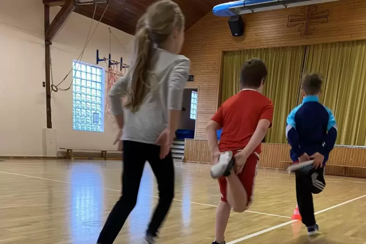 Beim Aufw&auml;rmen bestimmen die Jungen und M&auml;dchen einige &Uuml;bungen selbst, hier das Anfersen.