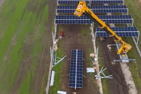 Mit einem Kran wird eine Agrar-Photovoltaik-Anlage im Wendland montiert.