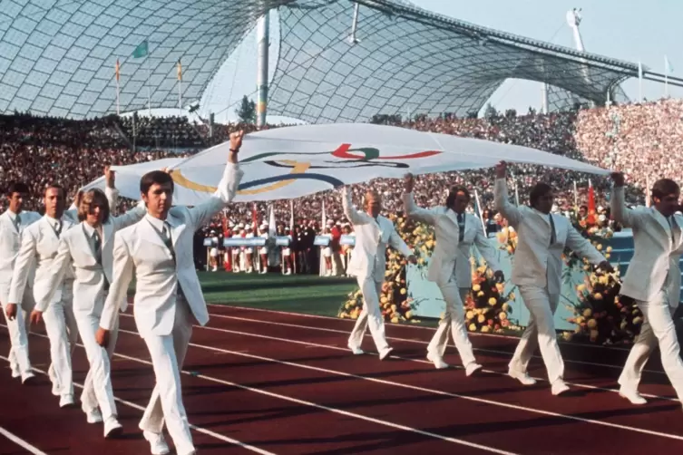 Die Fahne mit den fünf Ringen wird 1972 ins Olympiastadion in München getragen.