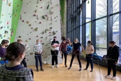Vertrauenssache: Sara Falk steigt mit Hilfe von Inklusionstrainerin Sonja Brand aufs Seil, das die Gruppe auf Spannung hält.
