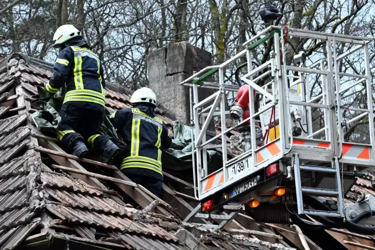 Die Hütte am Tag nach dem Sturm: Feuerwehrleute sichern das Dach.