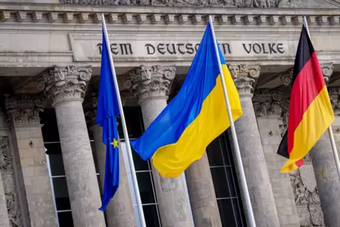 Vor dem Reichstagsgebäude: Die Fahne der Ukraine weht zwischen der deutschen und der europäischen Fahne im Wind.
