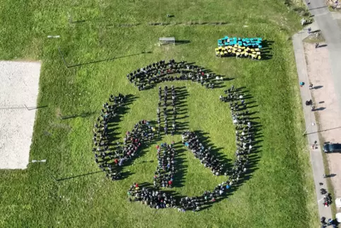 Rund 800 Schüler und Lehrer bilden das Peace-Zeichen.