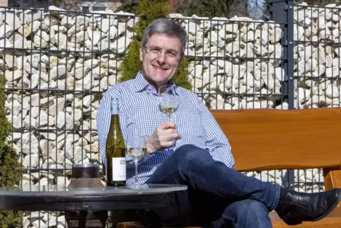  Paul Junker genießt die Sonne und einen guten Wein vor seinem Haus in Hütschenhausen an seinem selbst gebauten Tisch. 
