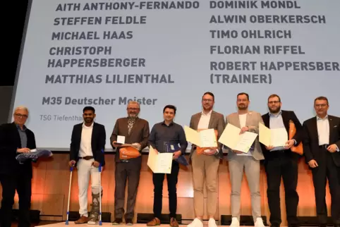Auf dem Podium der Meister: Die Ü35-Faustballer der TSG Tiefenthal werden von Sportminister Roger Lewentz (links) ausgezeichnet.