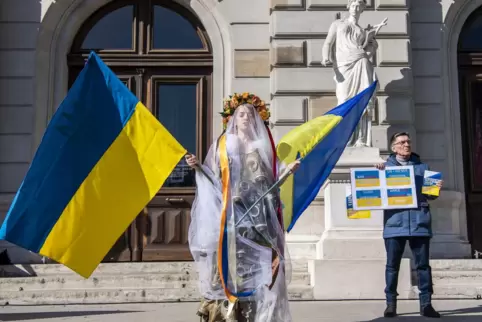 Eine Demonstrantin mit ukrainischen Fahnen in Genf. 