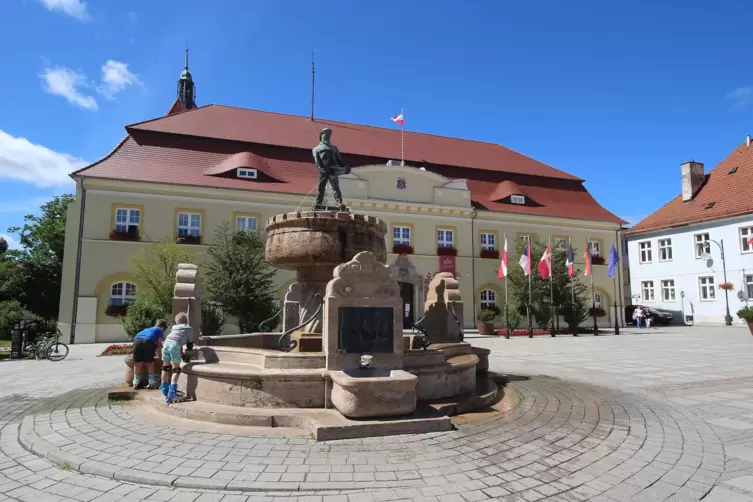 Darlowo: Rathaus (18. Jahrhundert) mit Fischerbrunnen von 1919.