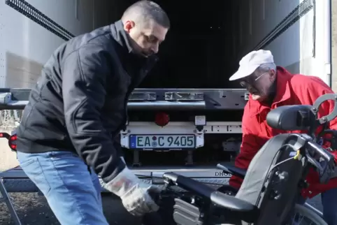Fahrer Jens Dirian und Bernd Moser (rechts) verladen einen Rollstuhl. Für den Hilfstransport hat Moser unter anderem auch medizi