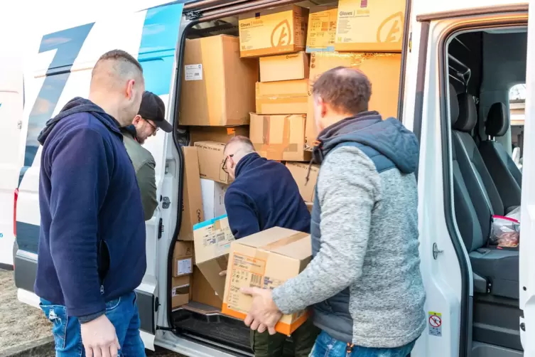 Helfer beladen ein Transportfahrzeug mit Spenden für die Ukraine.