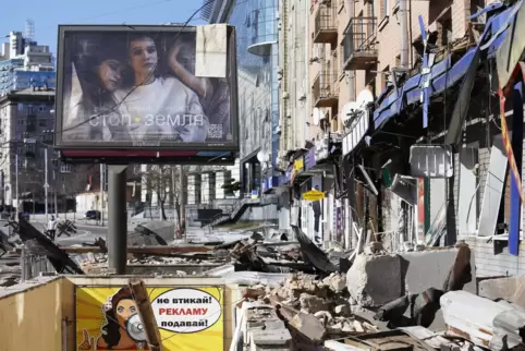 In Kiew liegen Trümmer auf einer Straße von Wohngebäuden und Geschäften. 