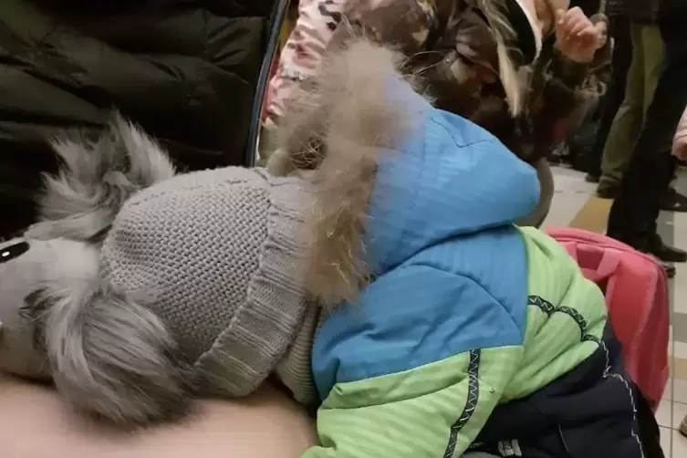 Ein ersch&ouml;pftes Kleinkind an der ukrainisch-polnischen Grenze. 