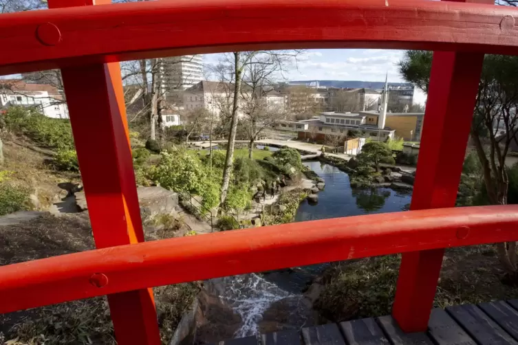 Ein Blick von der Brücke über den Japanischen Garten und die Stadt im Hintergrund.