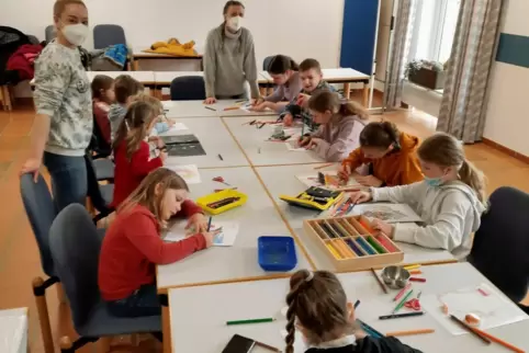 Die ukrainischen Kinder (rechts) malen gemeinsam mit Kindern aus der Kita „Haus des Kindes“ Bilder. Betreut werden sie von den E