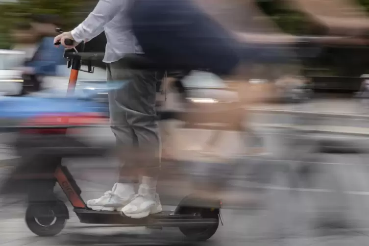 Ein Mann kreuzt mit einem E-Tretroller den Weg eines Fahrradfahrers. 