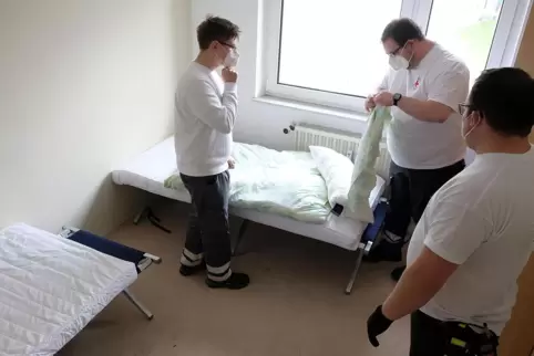 Marius Schmidt, Patrick Wagner und Jan-Hendrik Prager (von links) von der DRK-Katastrophenschutzeinheit schlagen in einem Wohnbl