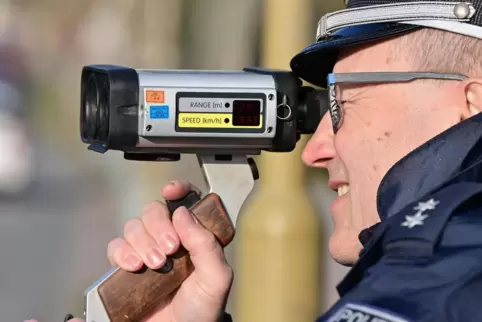Schneller als erlaubt? Ein Polizist misst die Geschwindigkeit eines Verkehrsteilnehmers mit einer Laserpistole.