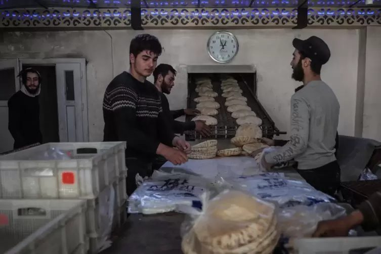 In einer Bäckerei der syrischen Stadt Idlib verpacken Arbeiter das aus Weizenmehl hergestellte Fladenbrot. 