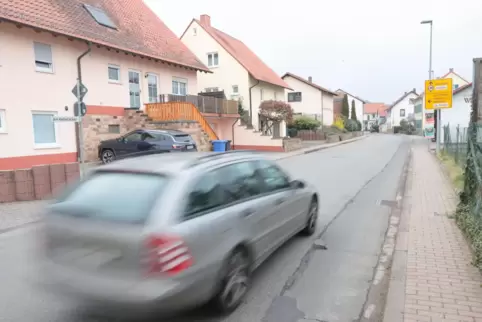 In Kleinkarlbach wird vielfach gerast. Hinter dem gelben Hinweisschild (vor der Schreinerei Weber) könnten zwei Parkplätze marki