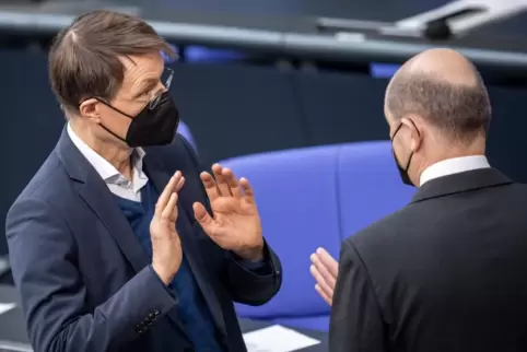 Bundeskanzler Olaf Scholz (r, SPD), spricht mit Karl Lauterbach (SPD), Bundesminister für Gesundheit, im Plenum im Bundestag. De