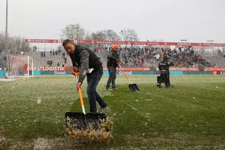 Schnee und Eis im Stadion am Dallenberg: Helfer versuchen, den Rasen bespielbar zu machen. 