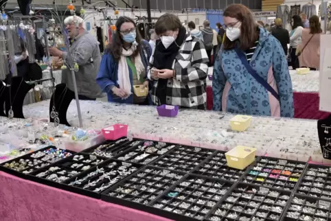 Neugierige Blicke mit Maske an einem Stand in der Eberthalle. 