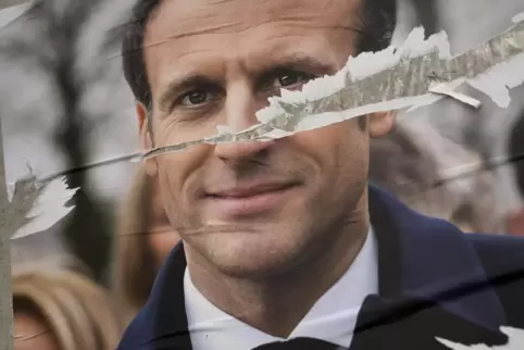 Hat er den Weckruf gehört? Ein zerrissenes Plakat des französischen Präsidenten Emmanuel Macron für die Präsidentschaftswahl in 