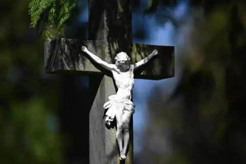 Salzburg: An einem Grab steht eine Darstellung des gekreuzigten Jesus. Der Karfreitag zählt zu den wichtigsten Tagen des Christe