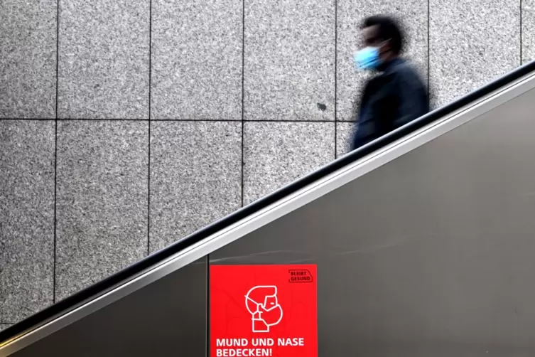 Ein Schild an einer Rolltreppe in Düsseldorf weist auf das Tragen einer Schutzmaske hin. Viele Menschen wollen laut einer Umfrag