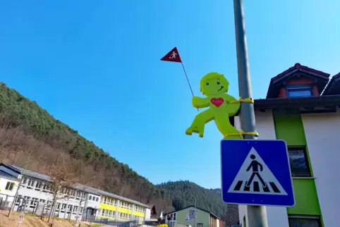 Eine Warnfigur hängt vor Schule und Kita in der Schulstraße. Sie soll Autofahrer zum langsamen Fahren anhalten und dadurch die S