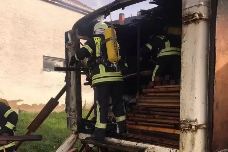 Zerst&ouml;rt: der auf einem Gel&auml;nde nahe des Bahnhofs in Berghausen geparkte Anh&auml;nger, den Feuerwehrleute gel&ouml;scht haben. 
