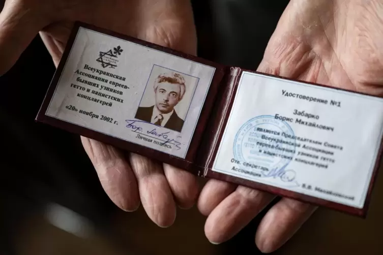 Der 86-jährige Borys Sabarko zeigt seinen Ausweis der Allukrainischen Assoziation der Juden, der Überlebenden der Ghettos und Ko